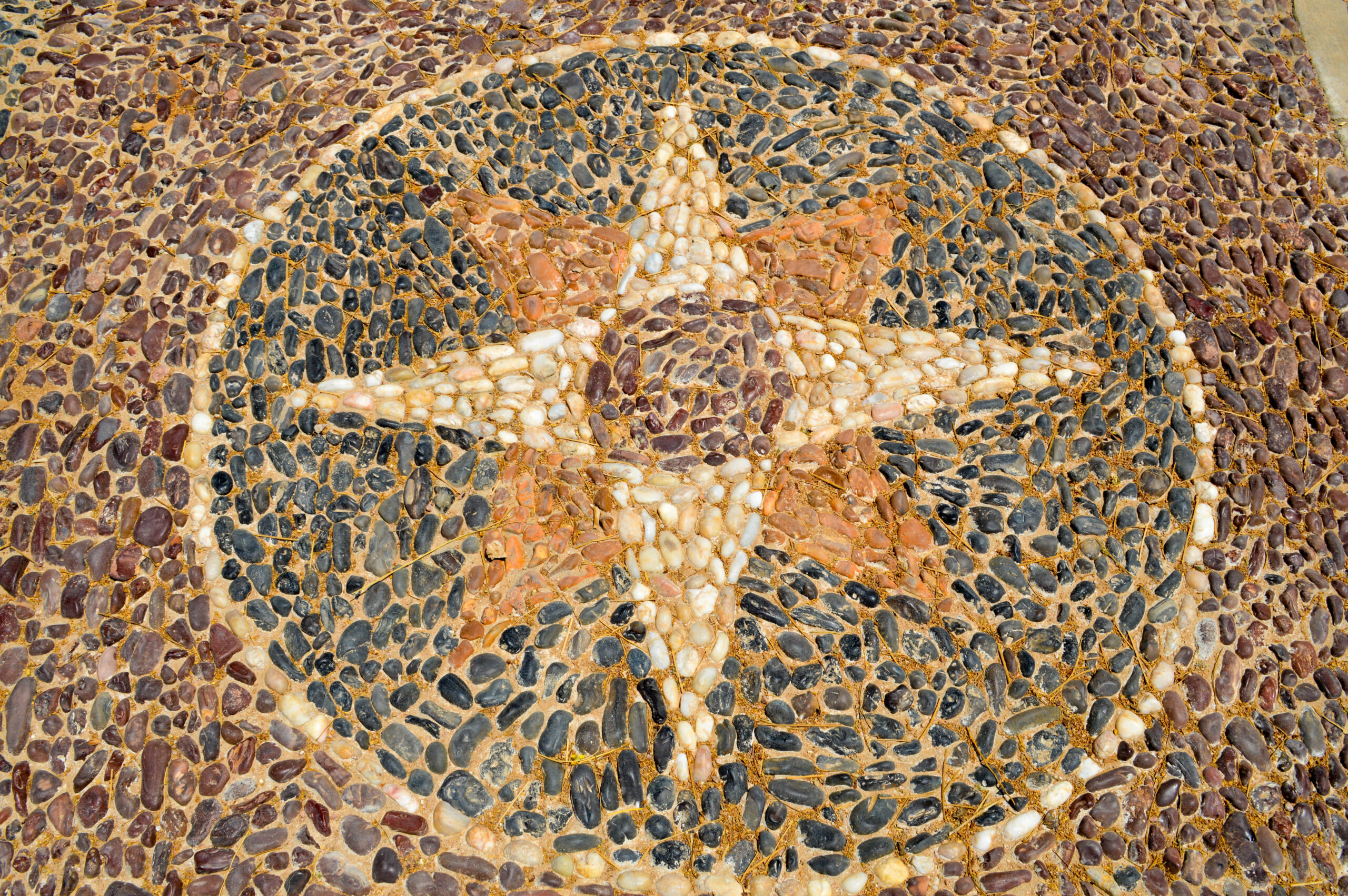 The texture of the stone wall, the road from small round and ova